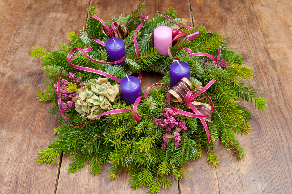 Adventkranz mit 3 Violetten und einer rose Kerze. 