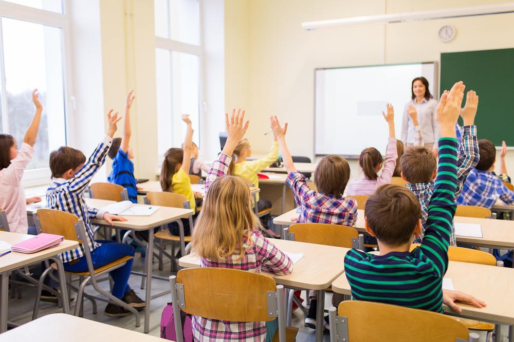 Unterrichtsstunde mit Schüler:innen die aufzeigen. / iStock/lev dolgachov, dolgachov Unterrichtsstunde mit Schüler:innen die aufzeigen.